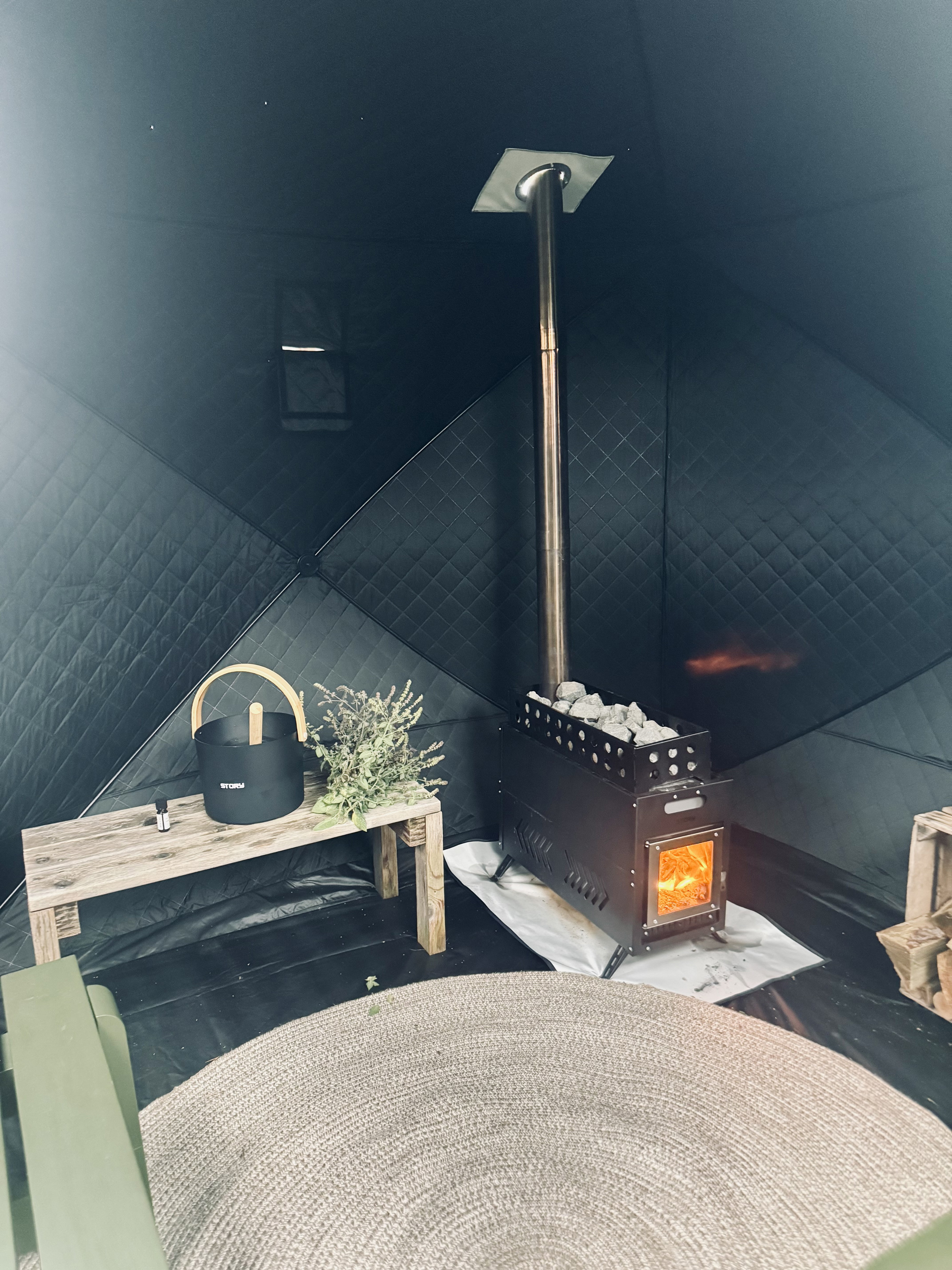 Story NovaHeat saunaovn tændt inde i Story HeatCamp saunatelt